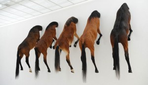 Artist Maurizio Cattelan exposition at Fondation Beyler Switserland horses with head in the wall